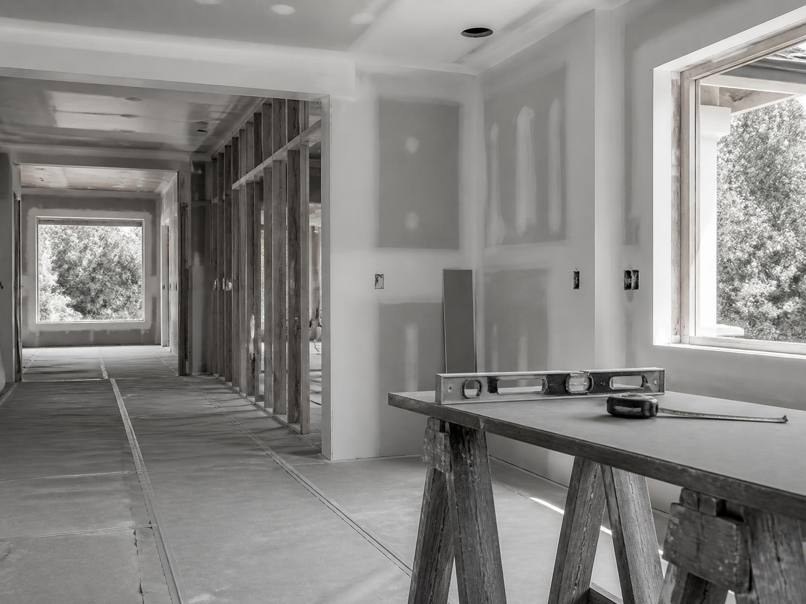 Residential remodel in progress with framed walls and taped drywall